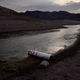 A buoy once used to warn of a submerged rock rests on the ground along the waterline near a closed boat ramp on Lake Mead.